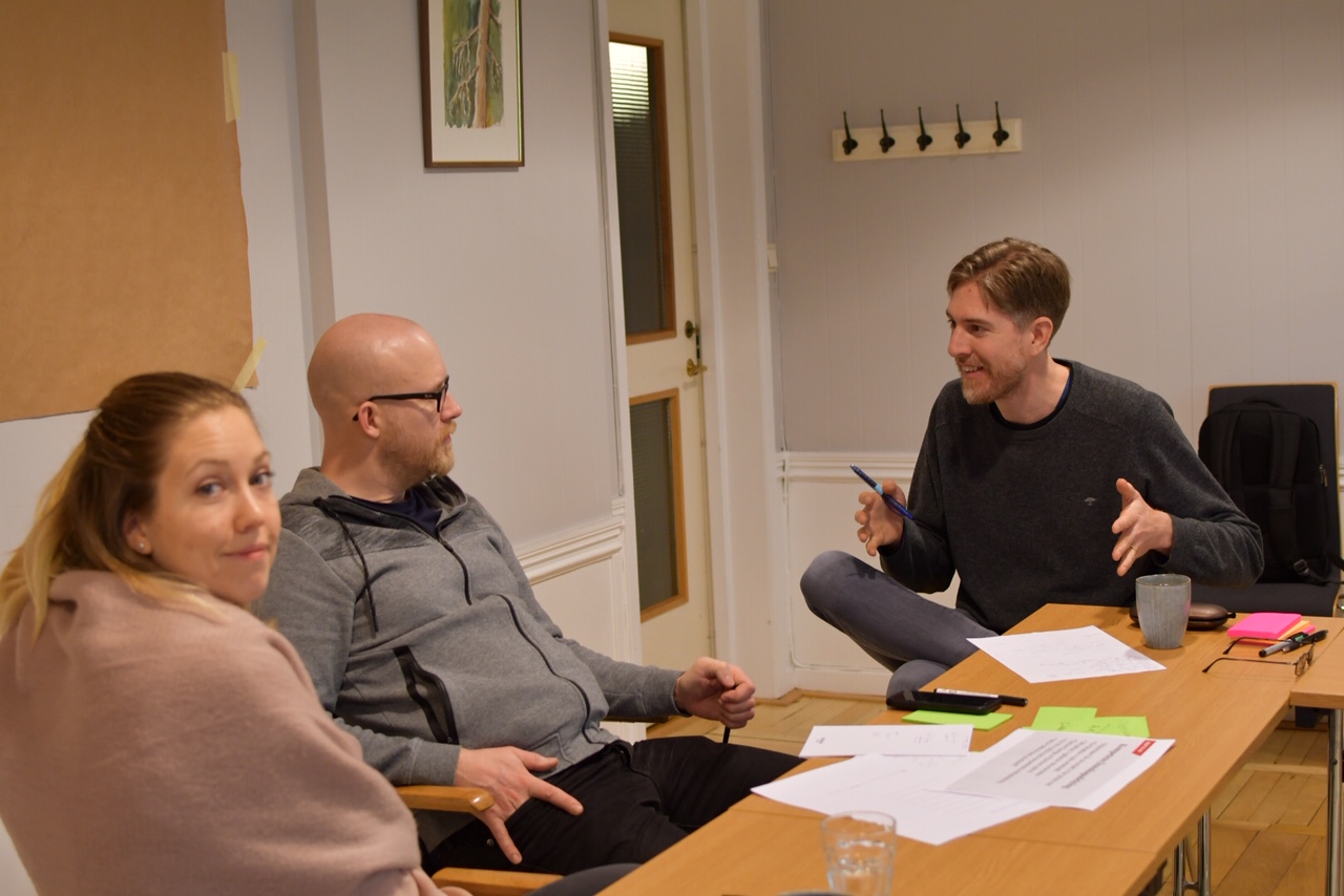 3 persons discussing at a conference table