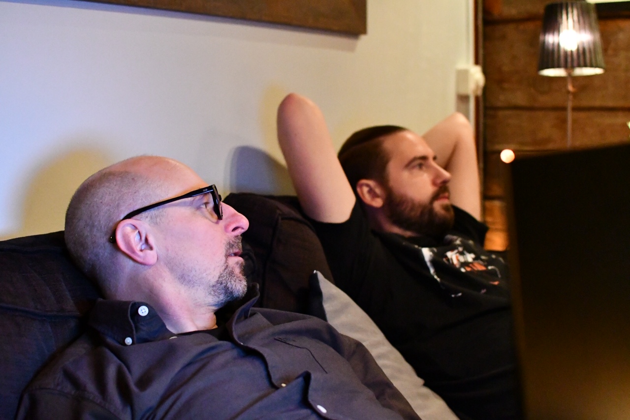 2 men on a sofa listening