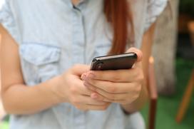 Kvinna som håller i en mobiltelefon