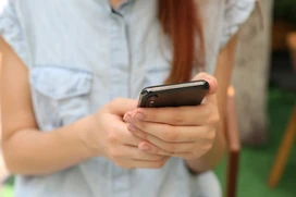 Kvinna som håller i en mobiltelefon