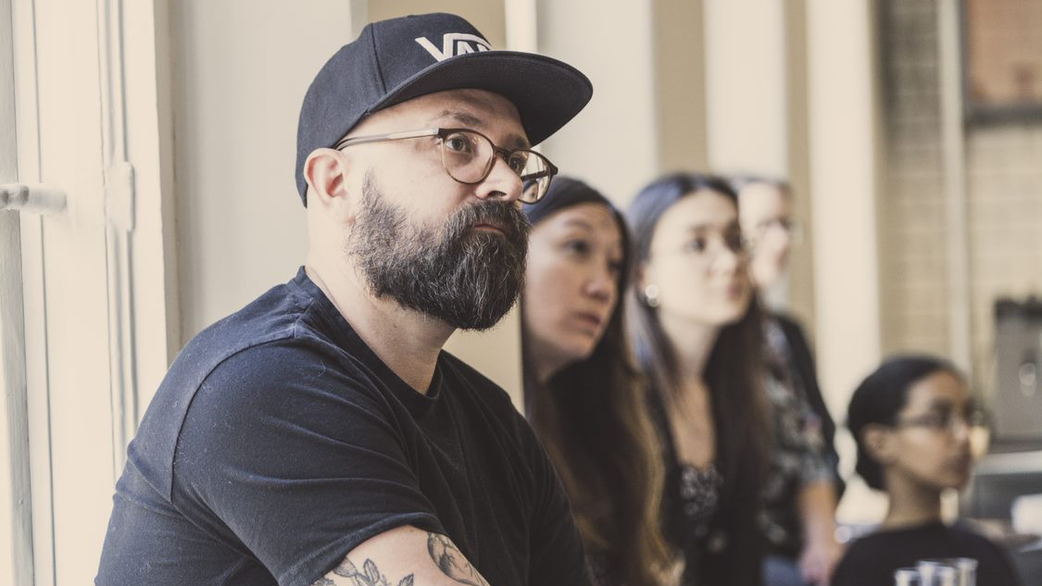 Johan listening in a conference room with people in the background