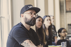 Johan listening in a conference room with people in the  background