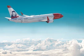 Norwegians flygplan i luften med moln under