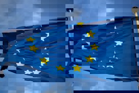 EUs blå och gula stjärnflagga med blå himmel i bakgrunden