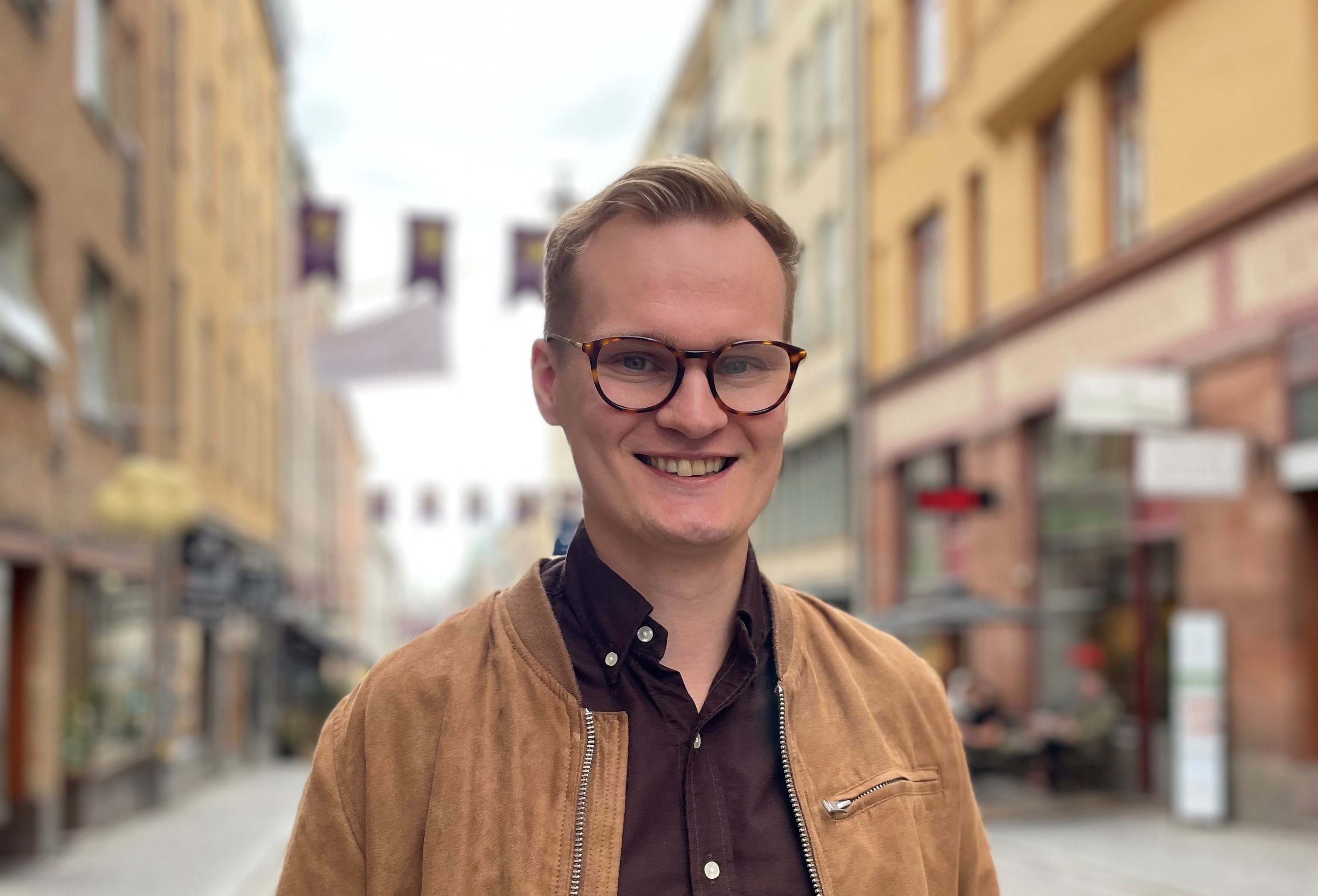 En glatt leende Joakim i gatumiljö