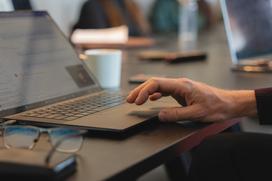 En hand som skriver på en på laptop