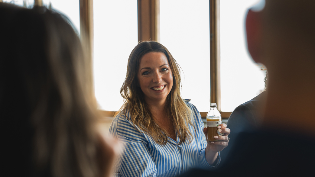 A smiling person in front of a window