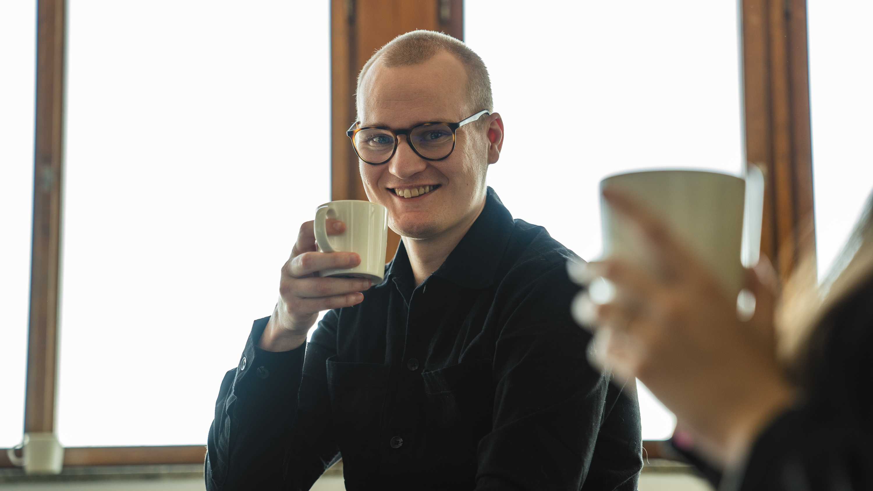 En medarbetare på Epinova dricker kaffe och är glad