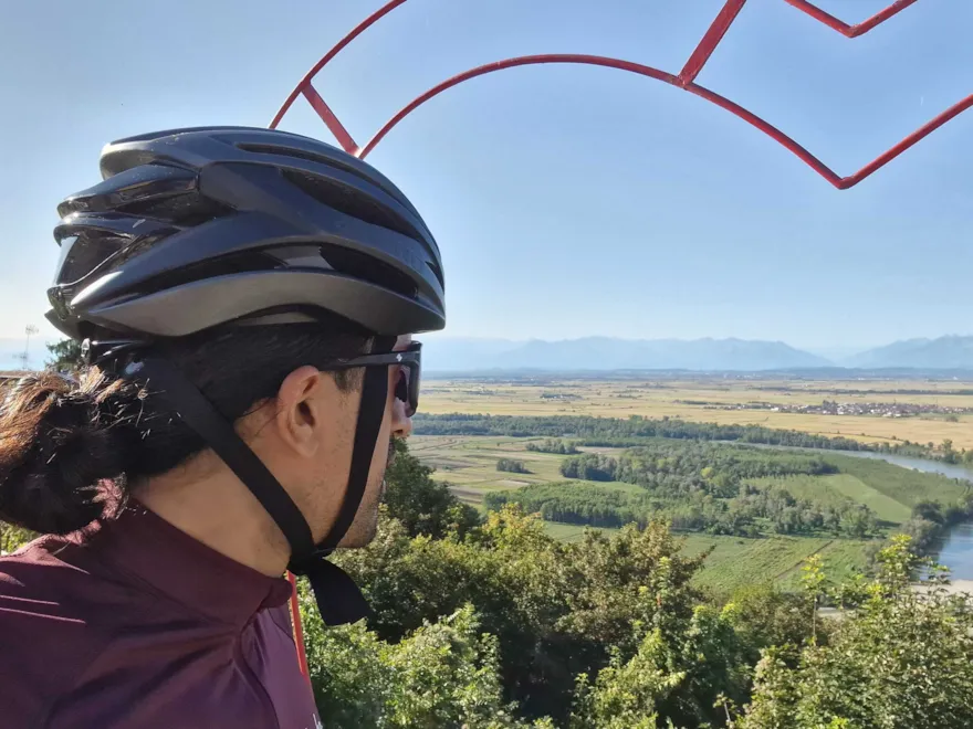 Sameer i cykelhjälm blickar ut över landskap