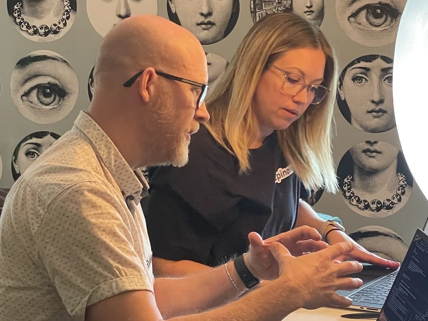 Two people conversing at desk