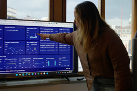 Woman pointing at statistics on screen