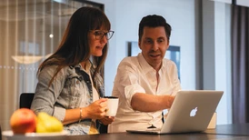 Two persons discussing in front of a computer