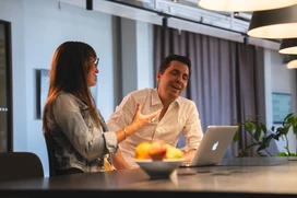 Två personer som ser glada ut i ett arbetsmöte