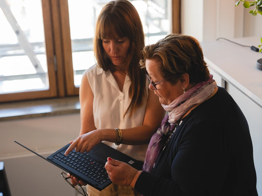 Två personer som diskuterar och tittar på en datorskärm