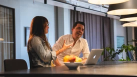 Two people looking happy in a work meeting
