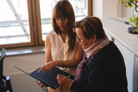 Two women looking at a screen in an open-plan office