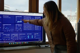 Woman pointing at statistics on screen