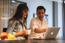 Two people discussing in front of a computer