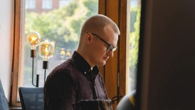 young man with glasses looking at screen