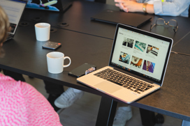conference room with a laptop on a table and the back of a woman 