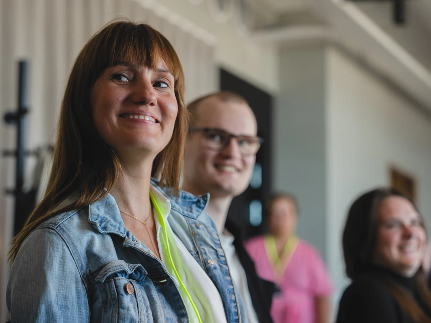 A smiling Christine with colleagues in the background