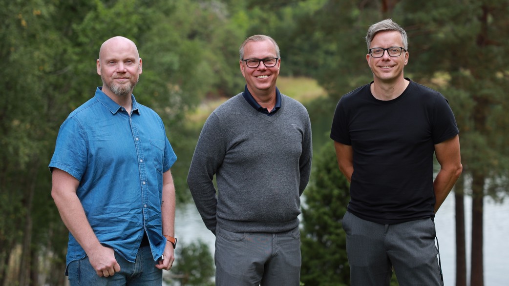 Joacim, Erik and Kalle outdoors with trees and water in the background