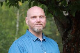 Joacim outdoors with trees and greenery in the background