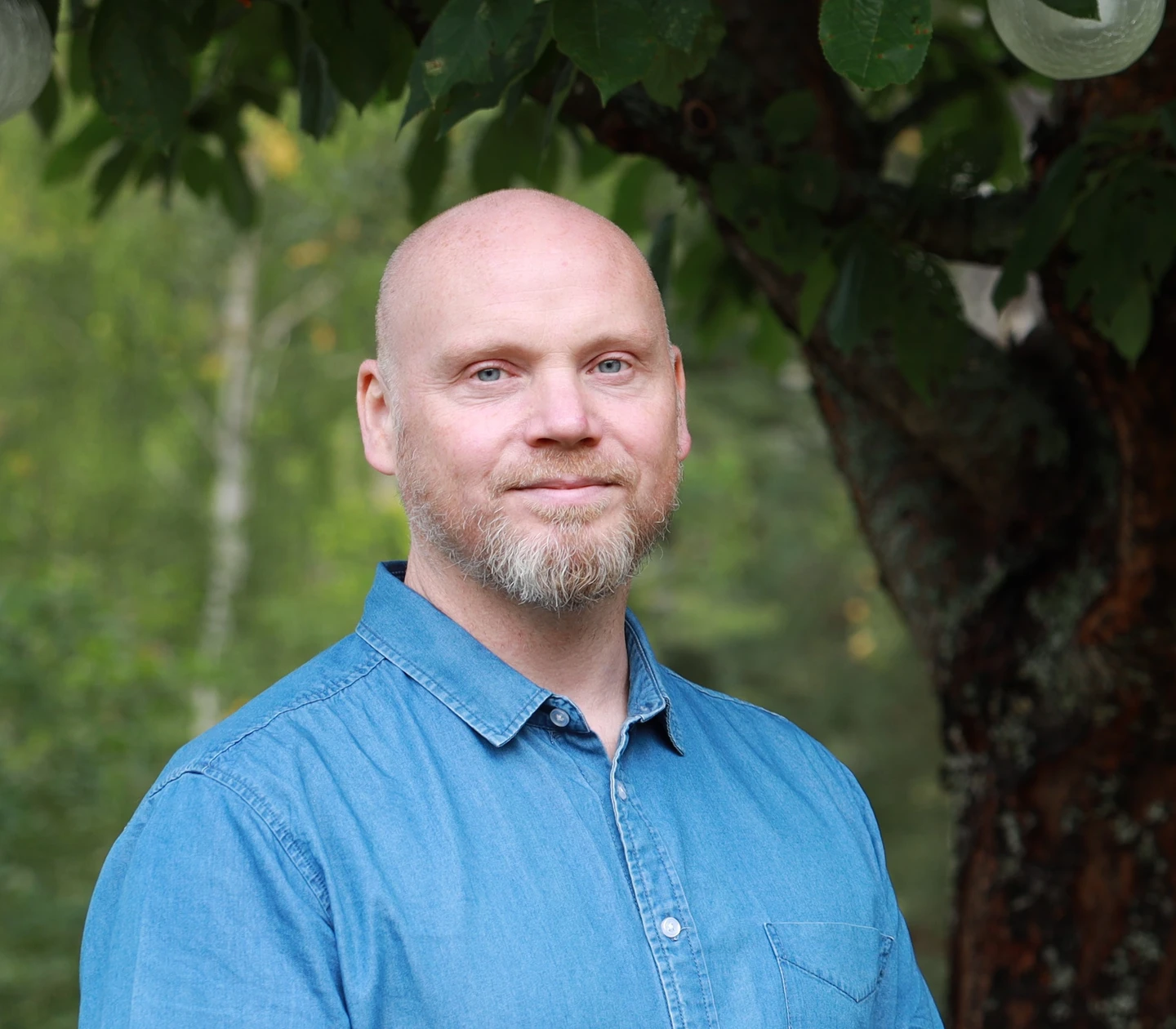 Joacim outdoors with trees and greenery in the background