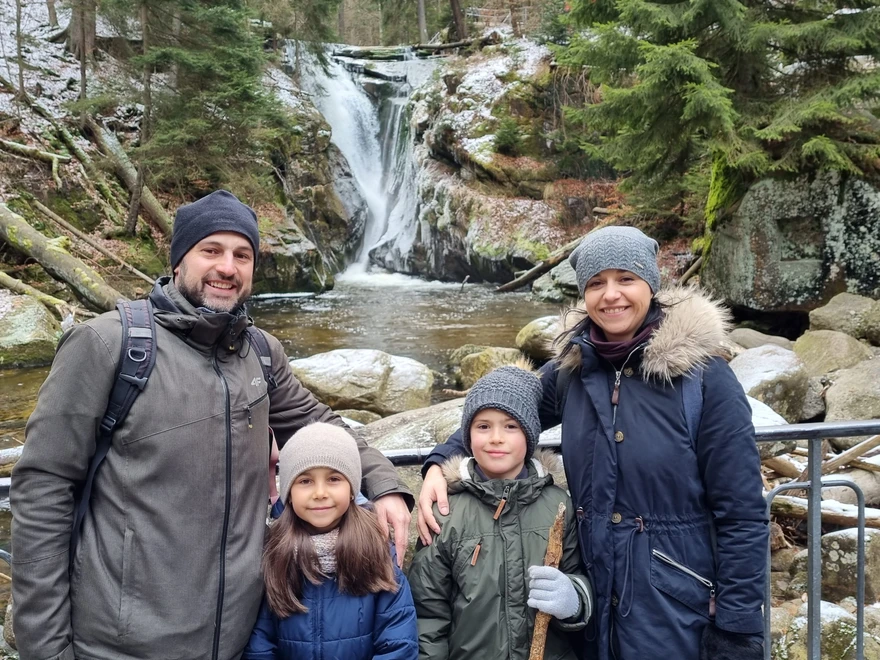 Edyta med sin familj framför ett vattenfall