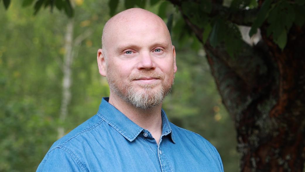Joacim utomhus med träd och grönska i bakgrunden