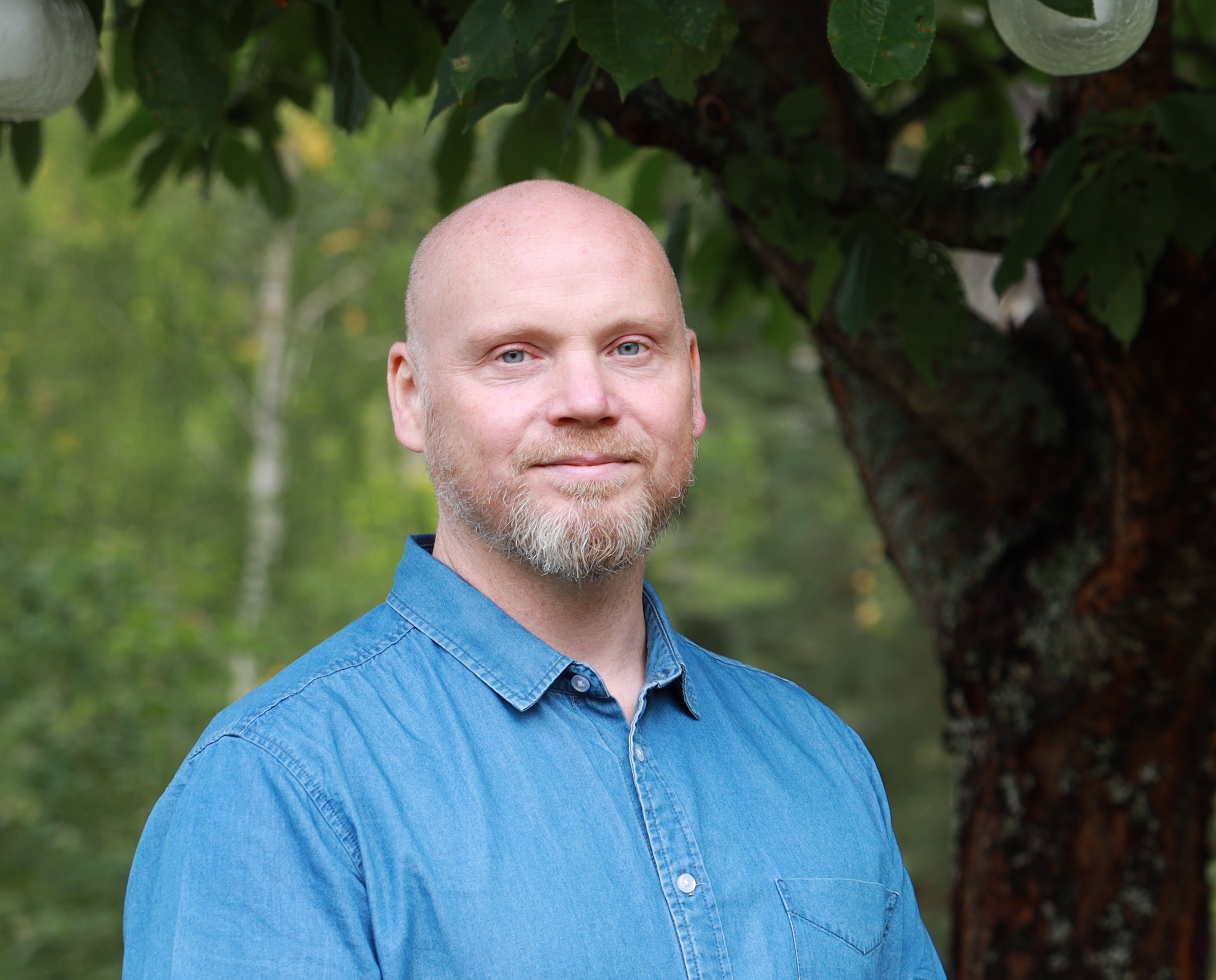 Joacim outdoors with trees and greenery in the background