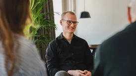 Joakim Sommar leende mot kollegor i möte